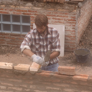 A man building a brick wall